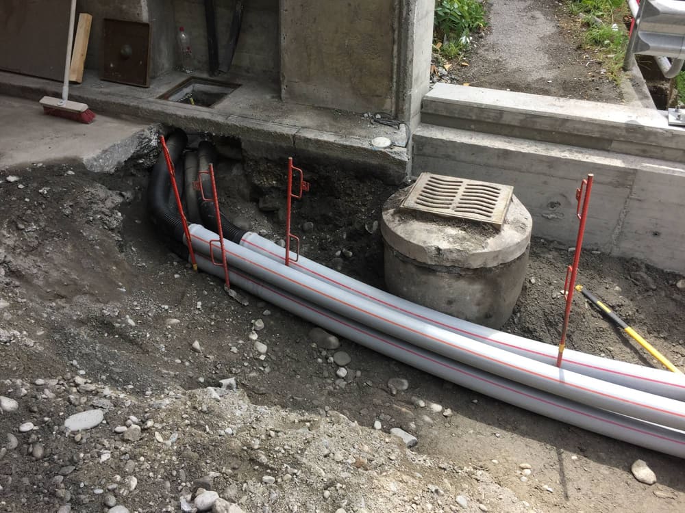 Neue Kabelschutzrohre beim Widerlager, daneben ein Einlaufschacht