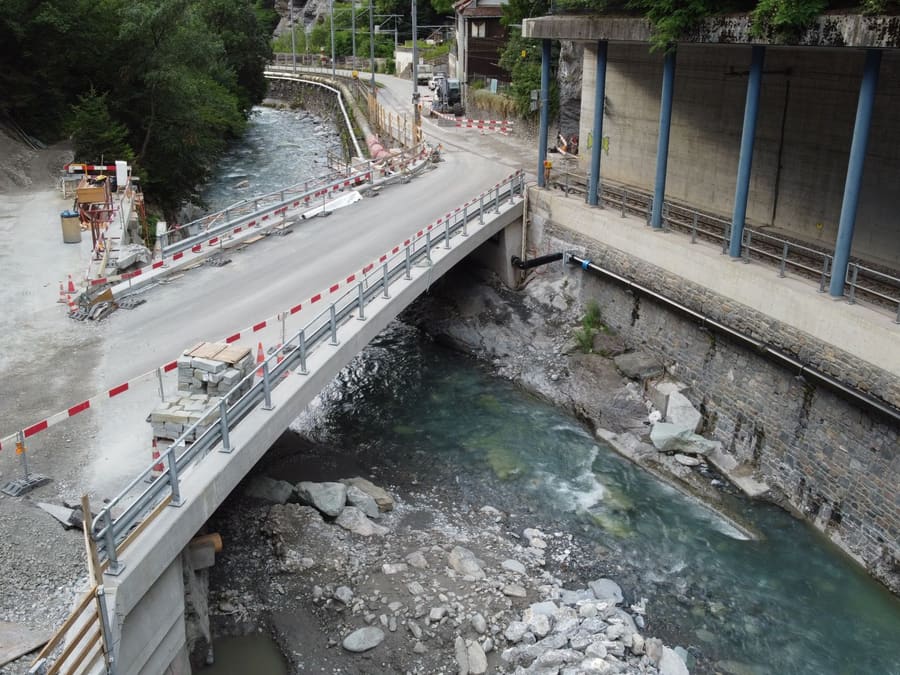 Neue Plessurbrücke Sassal aus der Luft kurz vor Bauende: Brücke mit Leitplanken über der Plessur, rechts die Bahnlinie unter einer Steinschlaggalerie, links der Installationsplatz